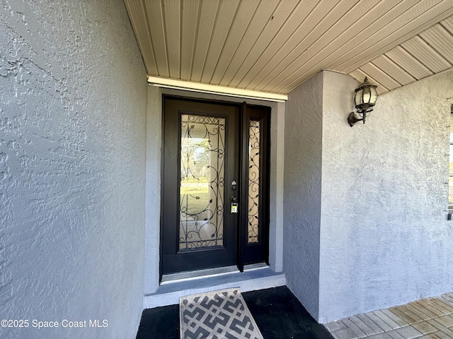 view of exterior entry with stucco siding