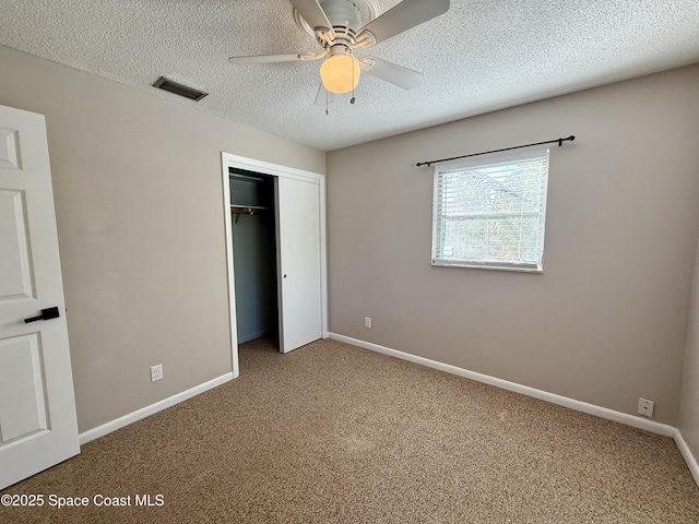 unfurnished bedroom featuring baseboards, visible vents, carpet floors, a closet, and a textured ceiling