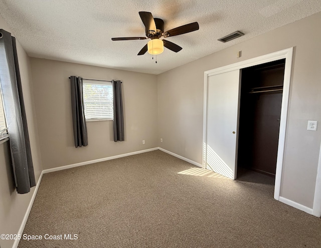 unfurnished bedroom with baseboards, visible vents, carpet floors, a closet, and a textured ceiling