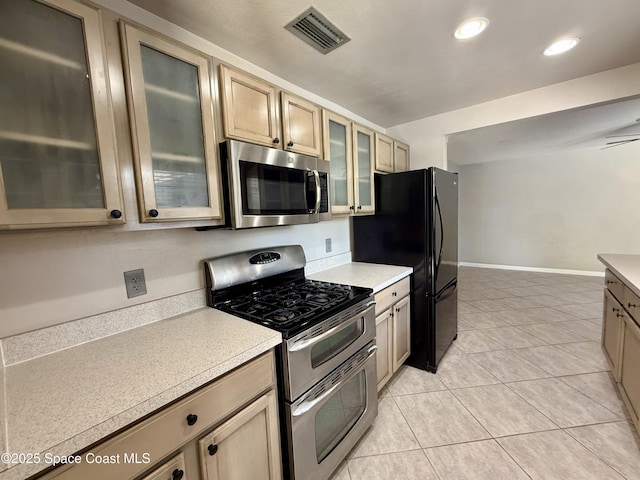 kitchen with light tile patterned floors, stainless steel appliances, visible vents, and light countertops