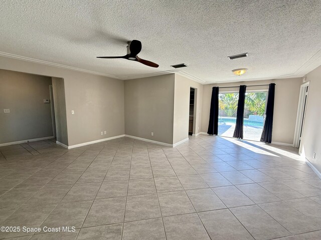 spare room with light tile patterned flooring, visible vents, baseboards, and ornamental molding