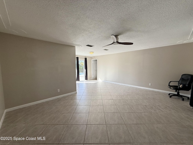 tiled spare room with a textured ceiling, a ceiling fan, visible vents, and baseboards