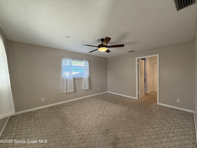 carpeted empty room with visible vents, ceiling fan, a textured ceiling, and baseboards