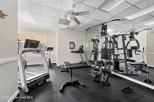 workout area featuring baseboards, a drop ceiling, and ceiling fan