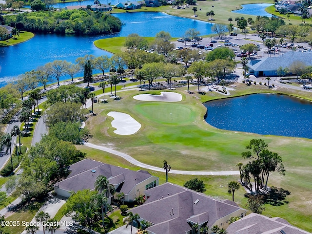 birds eye view of property with a water view and view of golf course