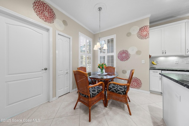 dining area with an inviting chandelier, light tile patterned flooring, baseboards, and ornamental molding