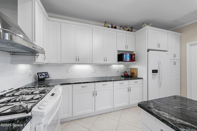 kitchen featuring visible vents, white appliances, wall chimney exhaust hood, white cabinets, and light tile patterned floors