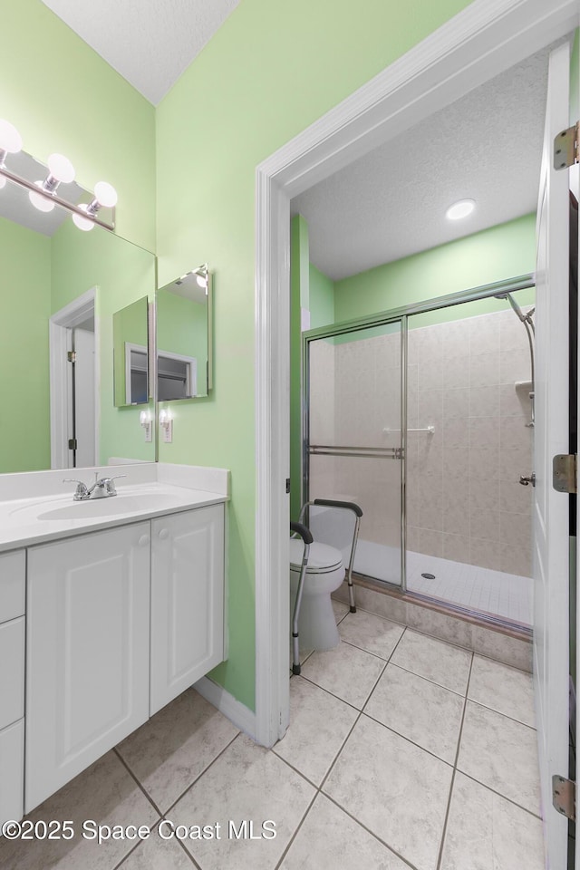 full bath featuring vanity, tile patterned floors, toilet, and a stall shower