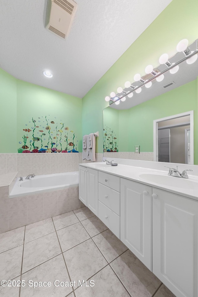 full bath with tile patterned flooring, visible vents, a garden tub, and a sink