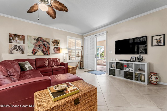 living area with light tile patterned floors, baseboards, crown molding, and a ceiling fan