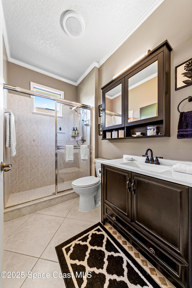 full bathroom featuring vanity, a shower stall, toilet, and ornamental molding