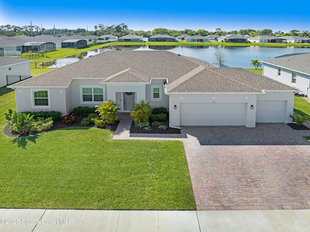 ranch-style house featuring decorative driveway, a residential view, a front lawn, and an attached garage