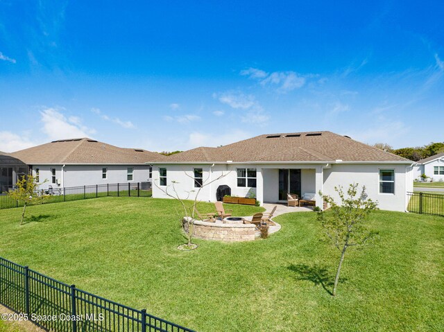 rear view of house featuring a lawn, an outdoor fire pit, a fenced backyard, and stucco siding