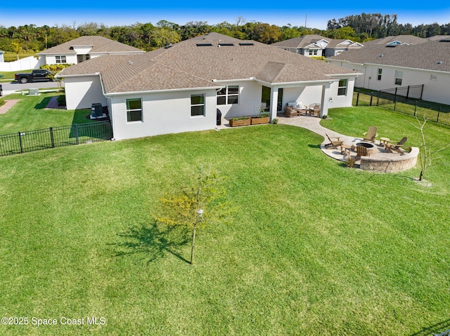 rear view of house with a yard, a patio, an outdoor fire pit, and a fenced backyard