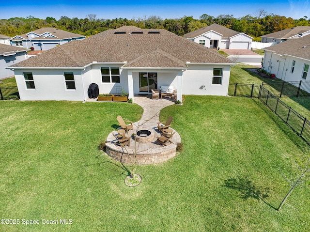 rear view of property with a fire pit, a shingled roof, a yard, a fenced backyard, and a patio
