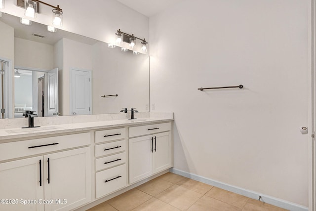 bathroom with baseboards, visible vents, double vanity, a sink, and tile patterned flooring