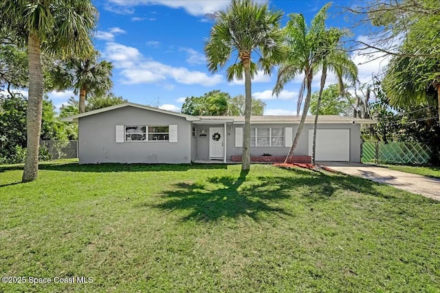 ranch-style house with an attached garage, a front lawn, fence, stucco siding, and driveway