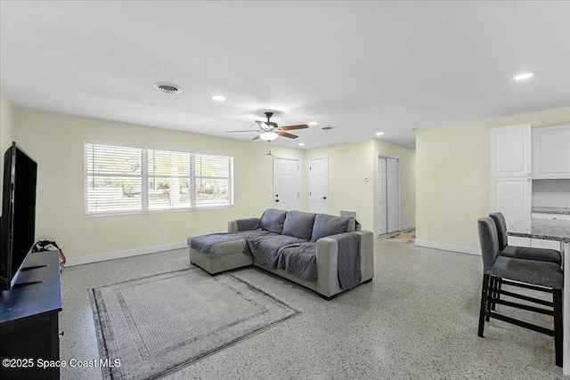 living area with recessed lighting, a ceiling fan, visible vents, and light speckled floor