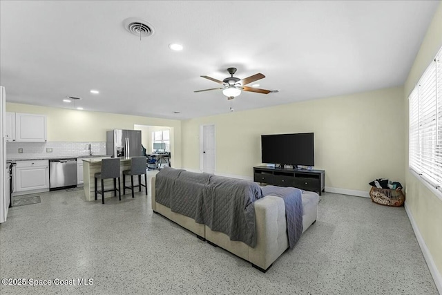 living area featuring visible vents, baseboards, recessed lighting, light speckled floor, and a ceiling fan