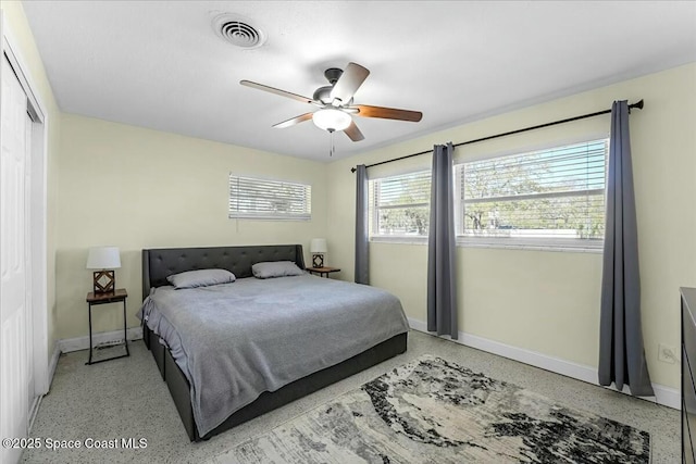 bedroom with visible vents, ceiling fan, light speckled floor, and baseboards