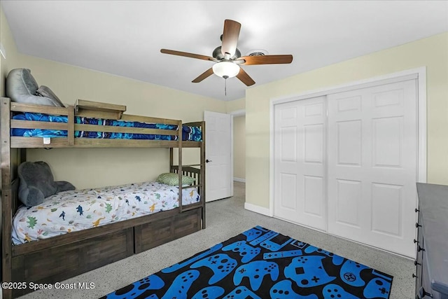 bedroom featuring a closet, baseboards, speckled floor, and ceiling fan