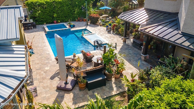 view of pool featuring a patio and a pool with connected hot tub