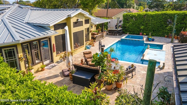 view of swimming pool featuring a pool with connected hot tub and a patio