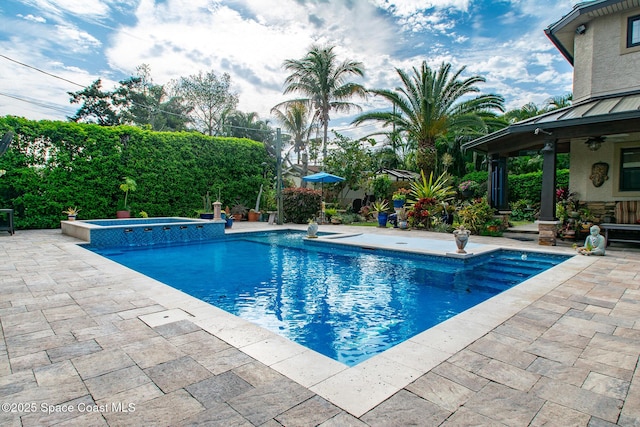 view of pool featuring a patio, a ceiling fan, and a pool with connected hot tub