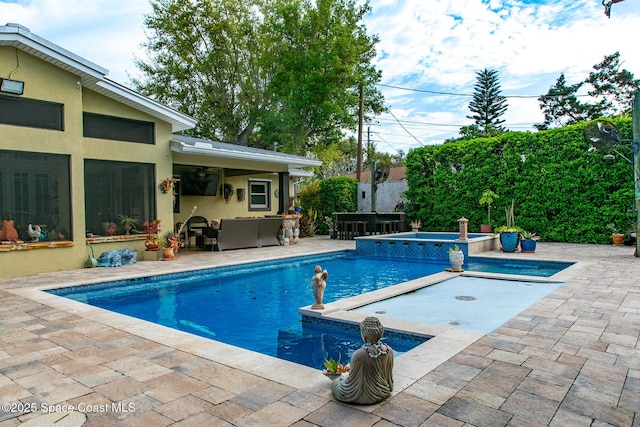 view of swimming pool featuring a patio, outdoor lounge area, and a pool with connected hot tub