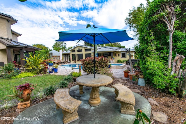 view of patio / terrace featuring a jacuzzi and an outdoor pool