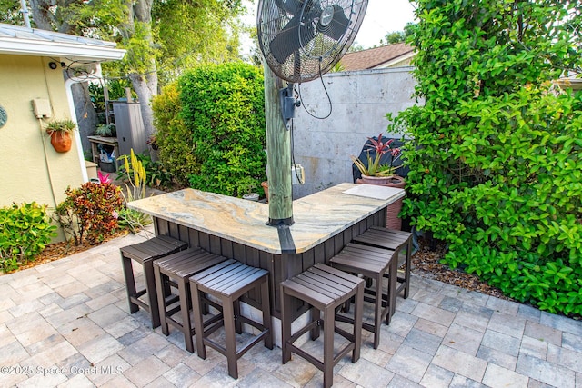 view of patio / terrace featuring outdoor dry bar and fence