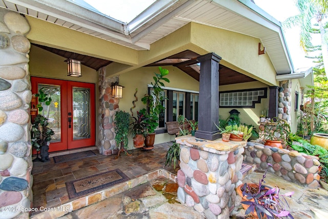 doorway to property featuring french doors and stucco siding