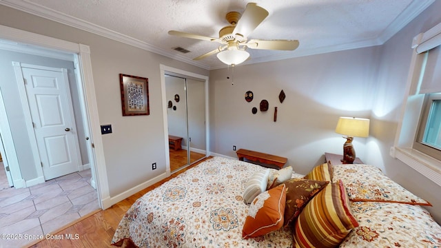 bedroom featuring crown molding, wood finished floors, visible vents, and a closet