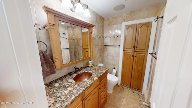 bathroom with tile patterned flooring, toilet, tile walls, and vanity