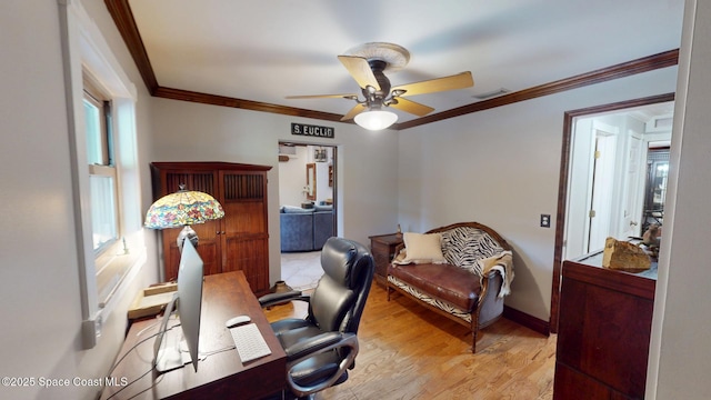 office space featuring a ceiling fan, baseboards, wood finished floors, visible vents, and ornamental molding