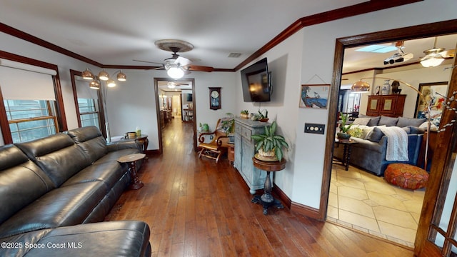 living room featuring ornamental molding, baseboards, and hardwood / wood-style flooring