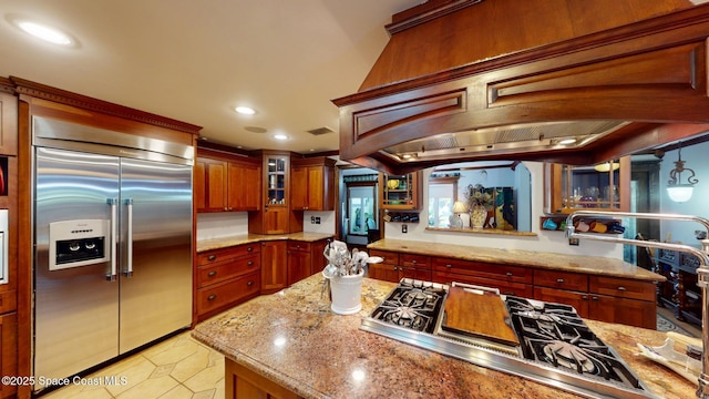 kitchen with glass insert cabinets, light stone counters, light tile patterned floors, recessed lighting, and stainless steel appliances