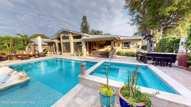 view of swimming pool featuring an outdoor hangout area, a patio, outdoor dry bar, and a pool with connected hot tub