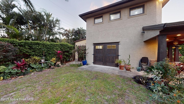 view of property exterior with stucco siding and a lawn