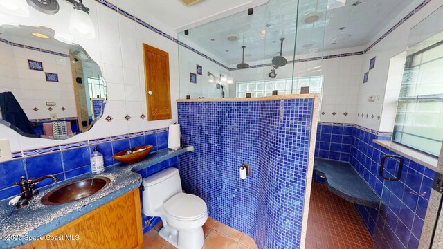 full bath featuring tile walls, a healthy amount of sunlight, and a tile shower