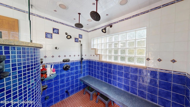 bathroom featuring tile patterned floors, tiled shower, and tile walls