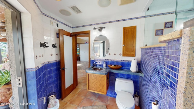 full bathroom with tile patterned flooring, tile walls, and visible vents