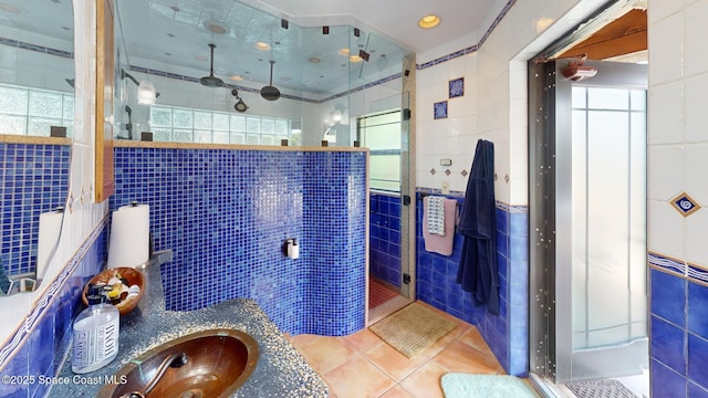 full bathroom with a shower stall, tile walls, vanity, and tile patterned floors