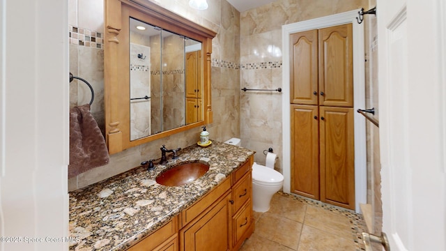 bathroom featuring tile patterned flooring, toilet, tile walls, and vanity