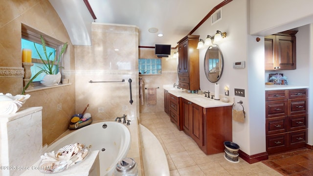 bathroom featuring vanity, a tub with jets, visible vents, baseboards, and tile walls