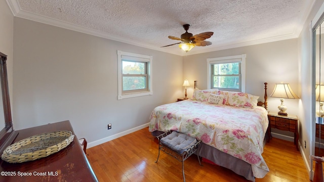 bedroom with a textured ceiling, crown molding, baseboards, and wood-type flooring