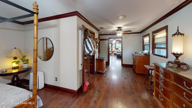 hall with dark wood-type flooring, baseboards, and ornamental molding