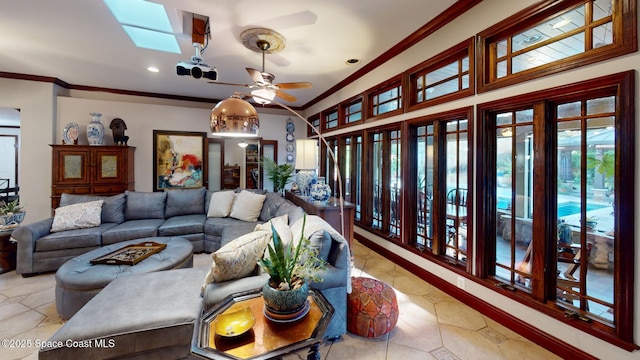 living room featuring light tile patterned flooring, a skylight, crown molding, and a ceiling fan