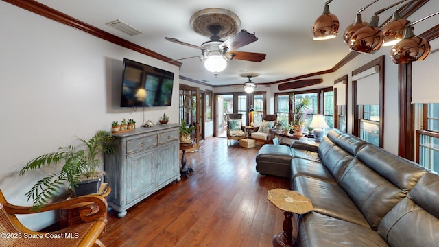 living area featuring visible vents, an inviting chandelier, dark wood finished floors, and crown molding