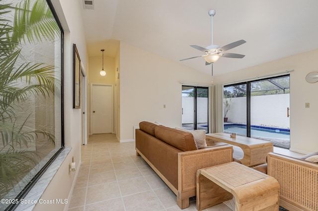 living room featuring visible vents, baseboards, lofted ceiling, light tile patterned flooring, and a ceiling fan